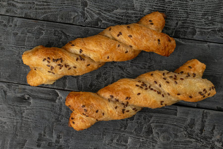 Rustic Twisted Pastries with Flax Seeds on Dark Wooden Background