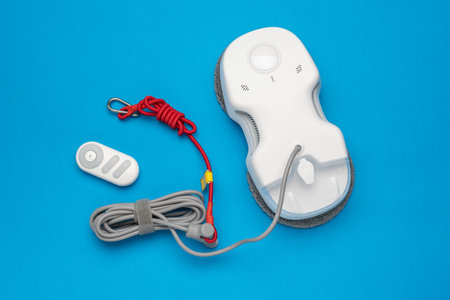 Robotic Window Cleaner and Remote Set on Blue Background - Modern Home Device Technology