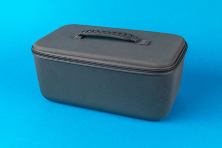 Black Rectangular Storage Case with Handle on Blue Backgroundの写真素材