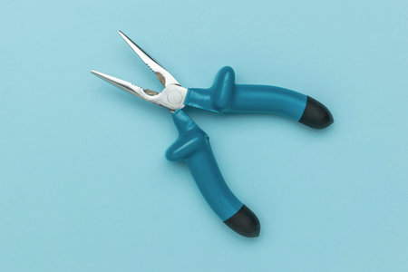Blue Handled Needle Nose Pliers on Minimalist Light Blue Background for DIY and Craft Useの写真素材