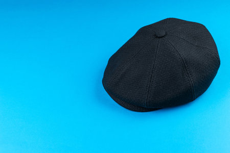 Black Newsboy Cap on Vibrant Blue Background - Classic Fashion Accessory