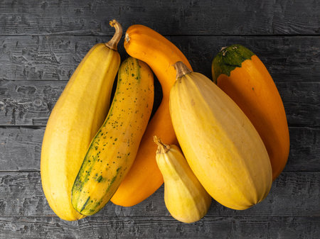 Assorted Yellow and Orange Squash on Rustic Wooden Surface: A Vibrant Autumn Harvest Displayの写真素材