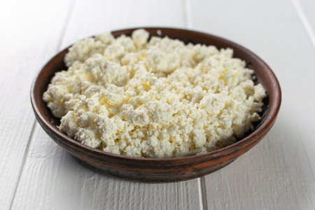 Fresh Cottage Cheese in Brown Bowl on White Wooden Table - Rustic Dairy Delicacyの写真素材