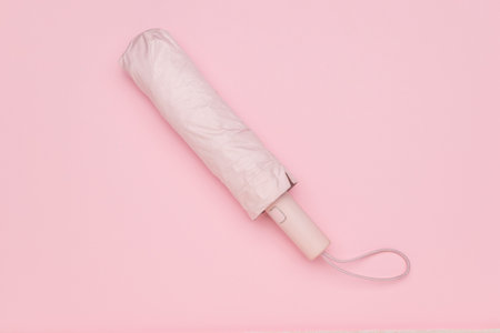 Compact Pink Umbrella on Minimalistic Pastel Background for Modern Lifestyleの写真素材