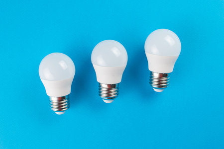 Trio of Energy-Efficient LED Light Bulbs on Vibrant Blue Backgroundの写真素材