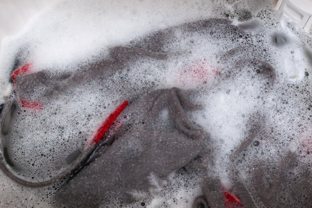 Gray and Red Fabric Handwashing in Soapy Water - Laundry and Cleaning Concepts in Stock Photographyの写真素材