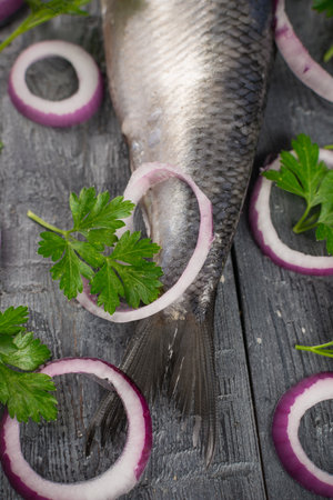 Fresh Herring with Red Onion and Parsley on Rustic Wooden Table for Culinary Delightsの写真素材