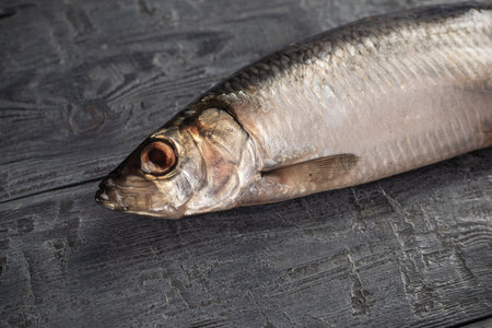 Fresh Herring Fish on Dark Wooden Surface for Culinary and Seafood Stock Photographyの写真素材