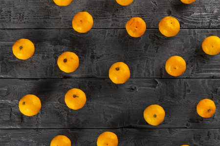 Vibrant Oranges on Rustic Dark Wood Background: Fresh Citrus Pattern for Modern Kitchen Decorの写真素材