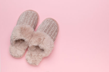 Cozy Furry Slippers on Pastel Pink Background for Relaxation and Comfortの写真素材