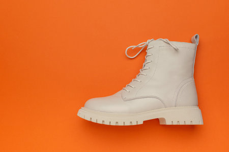 Minimal White Leather Boot on Vibrant Orange Background for Bold Fashion Statementの写真素材
