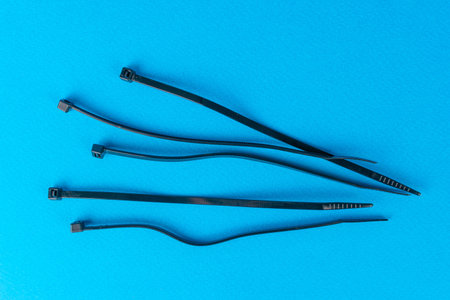 Black Cable Ties on Blue Background: Versatile Fastening Tools for Organization and DIY Projects
