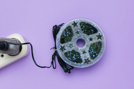 LED String Lights Rolled in Plastic Reel on Purple Background with Power Strip