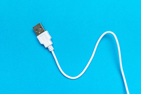 White USB Cable Against Vibrant Blue Background for Connectivity and Technology Concepts