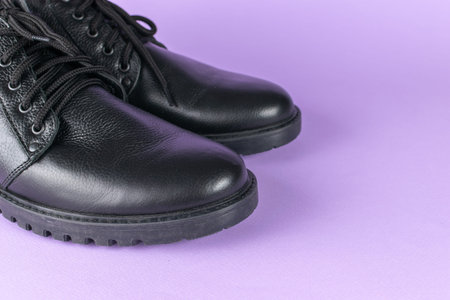 Black Leather Boots on Purple Background: Stylish Footwear Fashion Photography