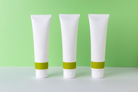 Minimalist Skincare Tubes on Green Background: Clean Beauty Packaging Concept