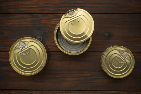 Top View of Open and Closed Tin Cans on Rustic Wooden Table Surfaceの写真素材