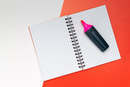 Open Notebook with Pink Highlighter on Red and White Backgroundの写真素材