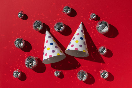Colorful Party Hats and Disco Balls on Vibrant Red Background for Festive Celebration