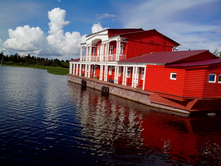 view of Kizhi Island, the historic site of churches and bell tower, a large historic log wood house on the marshy banks of islandの写真素材