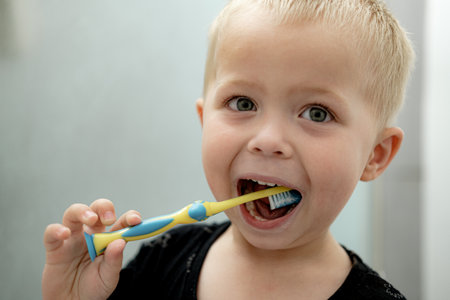 Little boy brushing his teeth in the bathroom. Oral hygiene concept.の写真素材