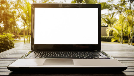 Conceptual workspace, Laptop with blank screen on a wooden table outdoors