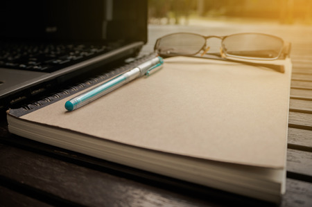Laptop on a wooden table outdoorsの写真素材