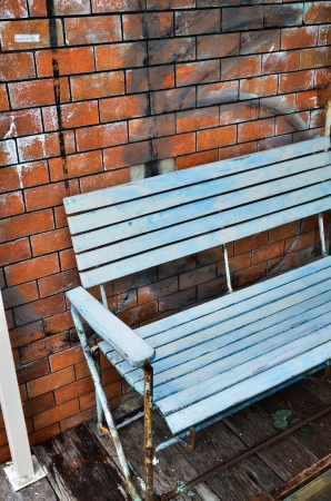 old bench and red brick wall background の写真素材