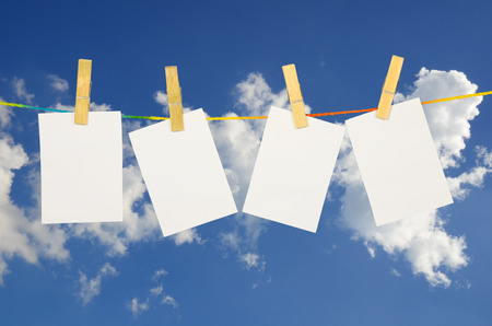 empty white photographs hanging on a clothesline with Blue Sky backgroundの写真素材
