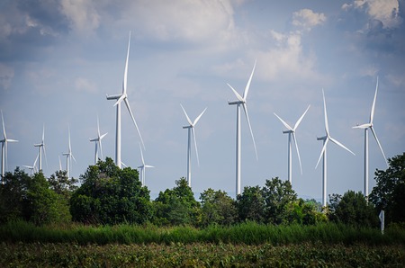 wind turbine against cloudy blue sky backgroundの写真素材