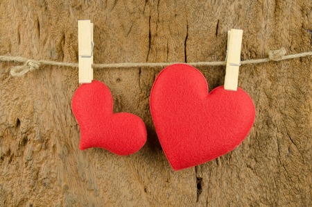 lovely red hearts hanging on the clothesline on old wood backgroundの写真素材