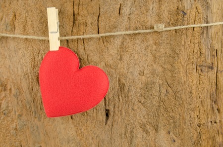 lovely red hearts hanging on the clothesline on old wood backgroundの写真素材