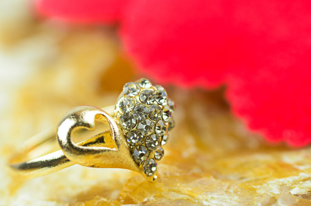 gold heart shape ring on marble stone backgroundの写真素材