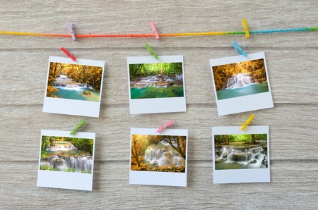 waterfall photos hanging with clothespins on wooden backgroundの写真素材