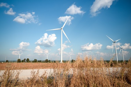 wind turbine against cloudy blue sky backgroundの写真素材