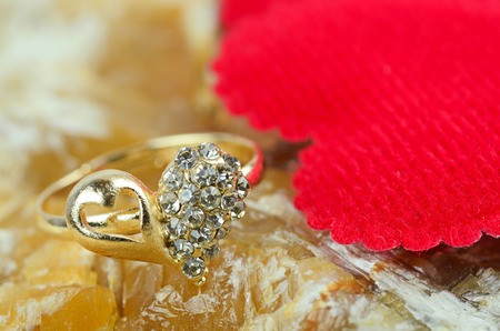 gold heart shape ring on marble stone backgroundの写真素材