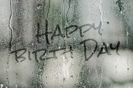 natural water drops on glass window with the text "Happy birth day"の写真素材
