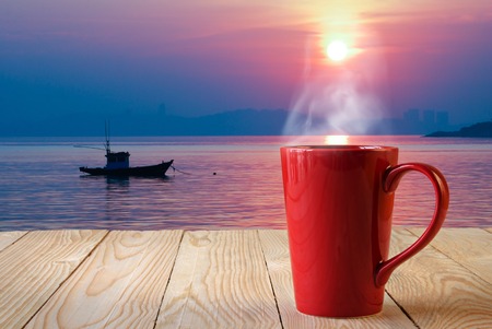 red coffee cup with smoke on sun rise backgroundの写真素材
