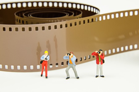 Miniature photographer with photo film backgroundの写真素材