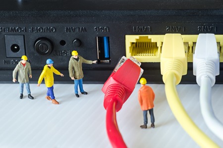 Miniature engineer team try to connect ethernet cables to portの写真素材
