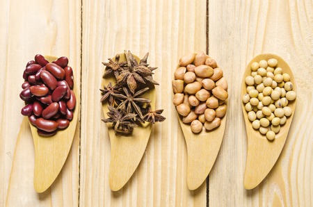 beans in wooden spoon on wood tableの写真素材