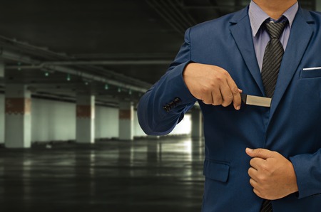 business man hand holding knife on unsafe zone background