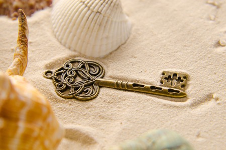 lost treasure key on sandの写真素材