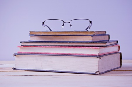 glasses on stack of book in vintage toneの写真素材