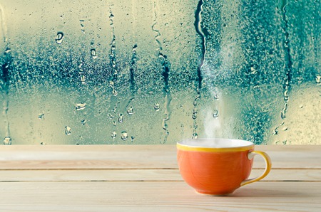 coffee cup with natural water drops on glass window backgroundの写真素材