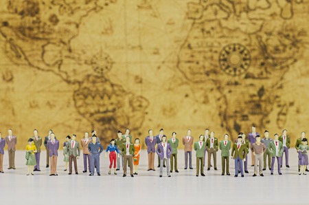 Miniature people on vintage map backgroundの写真素材