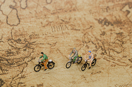 miniature people ride bicycle on vintage mapの写真素材