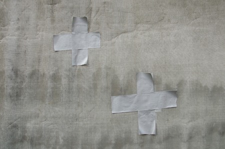 crossed duct tape strips on grunge canvas backgroundの写真素材