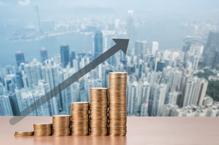 coins stack and arrow line up with city background , business conceptの写真素材