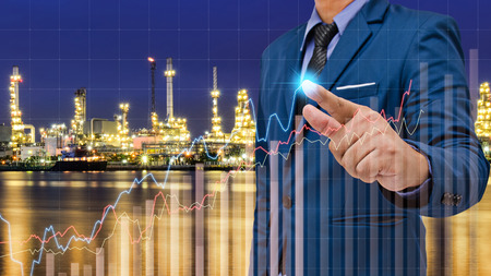 business man touch visual graph screen with oil refinery factory background, business conceptの写真素材